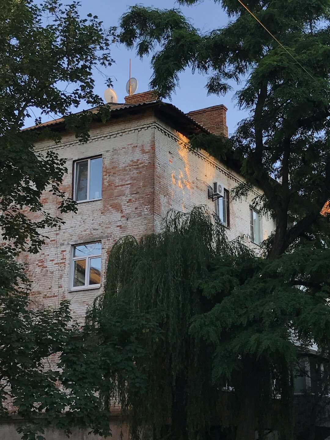 Stara kamena vila u sumrak s osvijetljenim prozorima i maglom